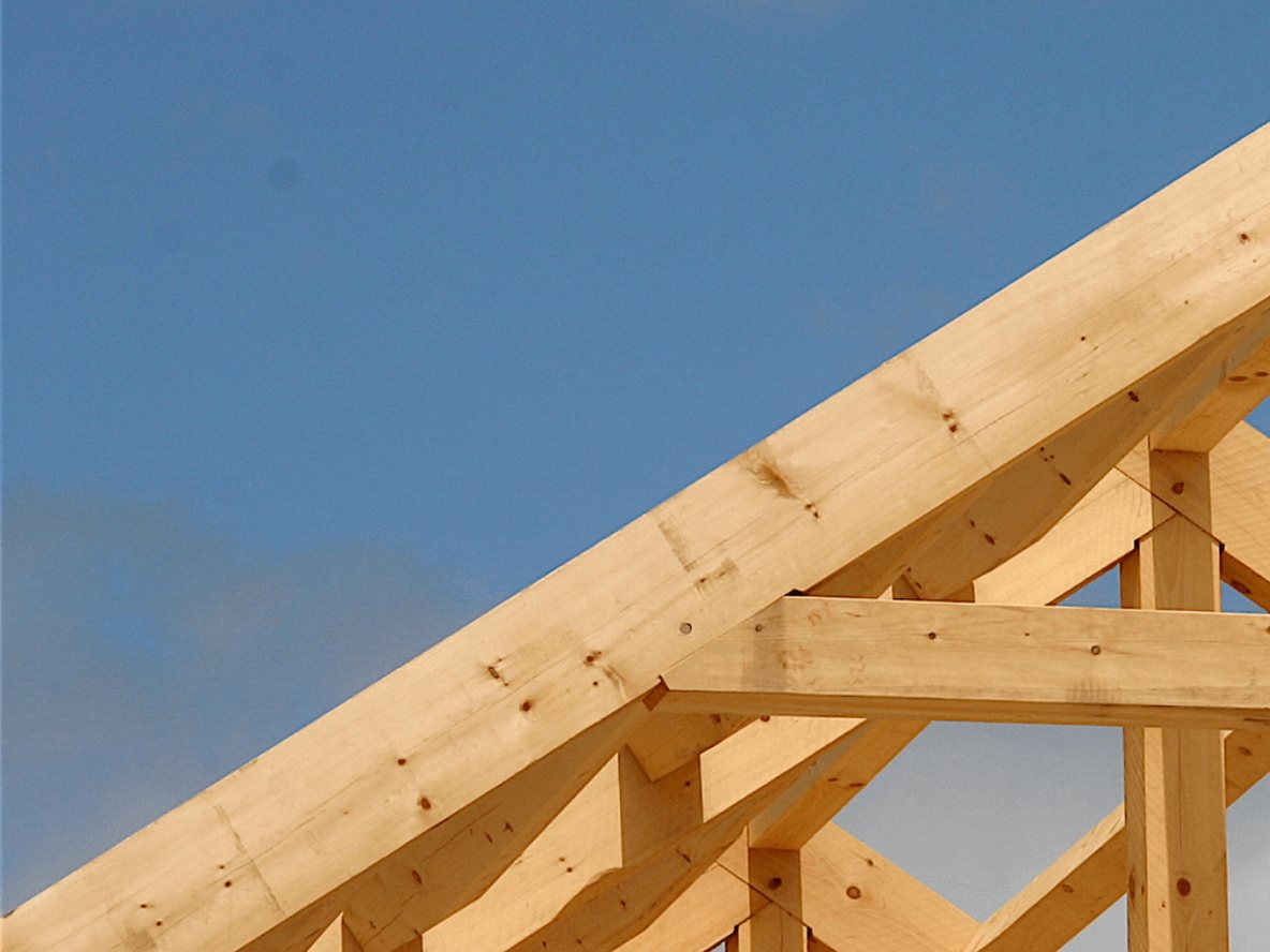 Timber roof trusses framed against open sky